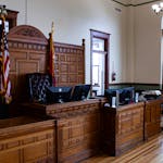 Interior view of an American courthouse in Kirksville, Missouri, featuring a judge's desk and flags.