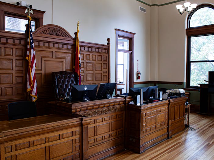 Interior view of an American courthouse in Kirksville, Missouri, featuring a judge's desk and flags.